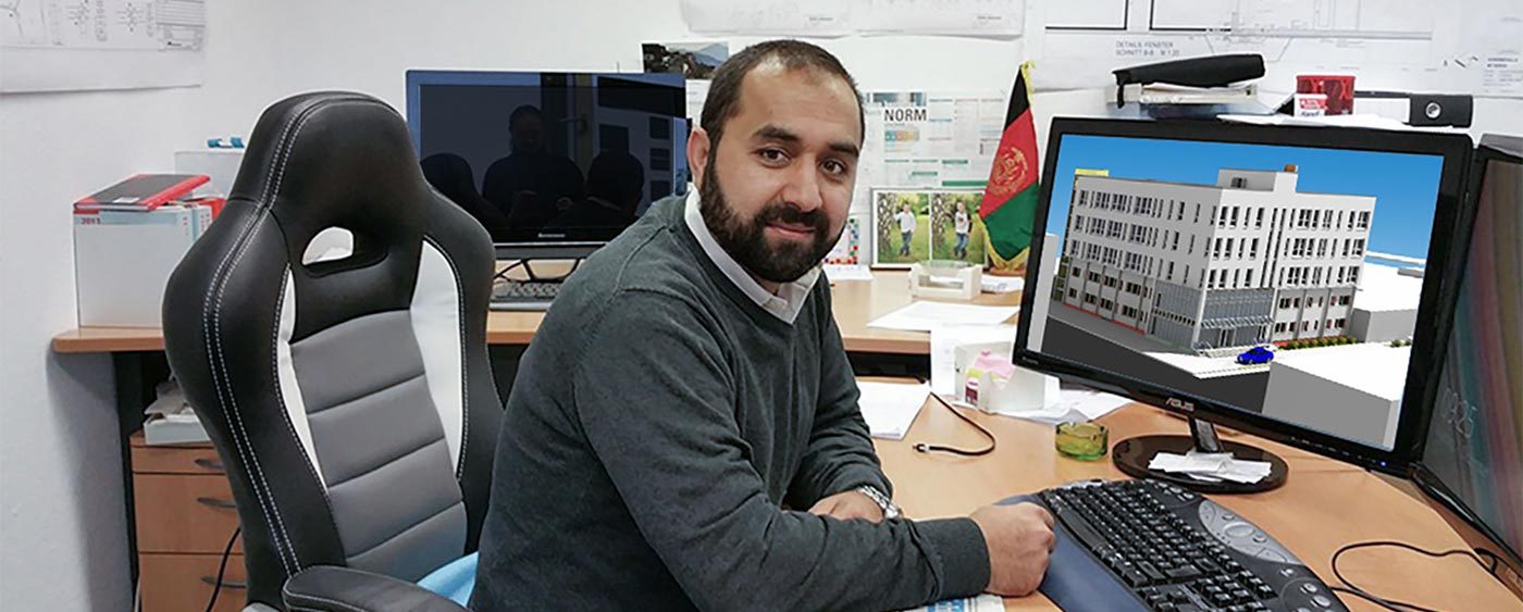 Mainodin Safi am Schreibtisch im Planungsbüro